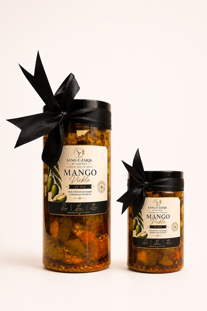Two glass jars of Sang-e-Saaron Mango Chutney in different sizes, decorated with black ribbon bows, on a clean off-white background.