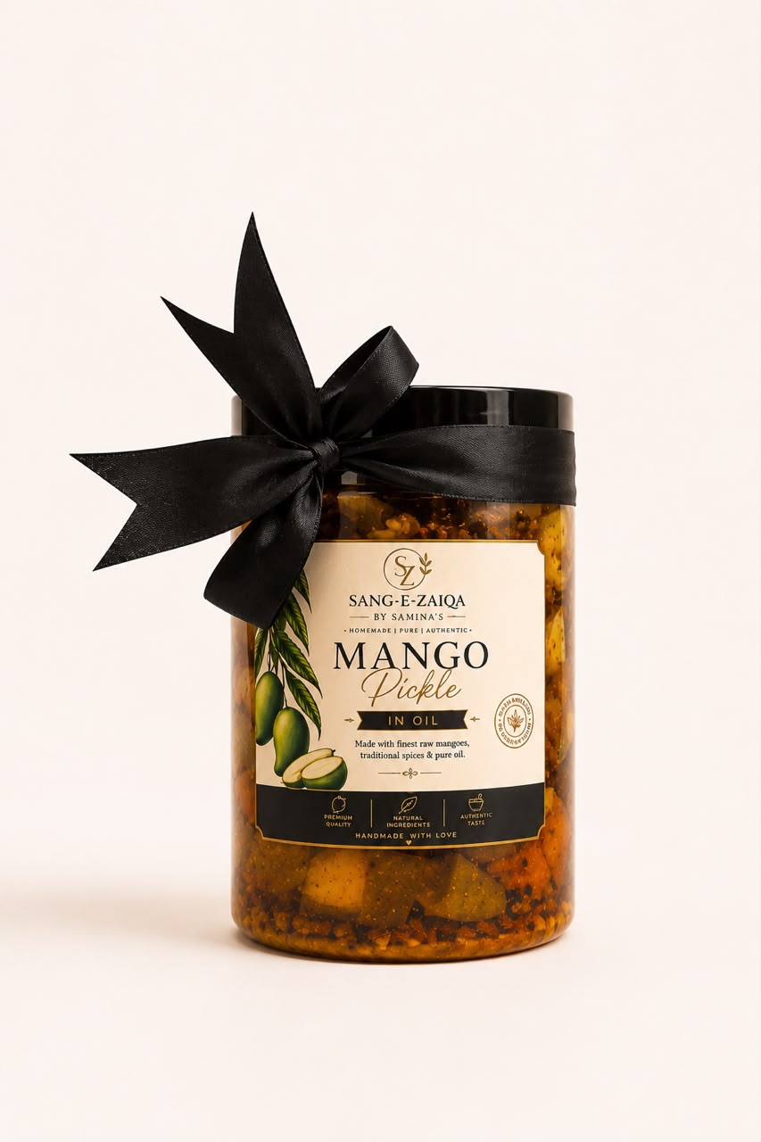 A glass jar of Sang-e-Zarqa Mango Pickle with a black lid and a black ribbon bow, set against a plain off-white background.