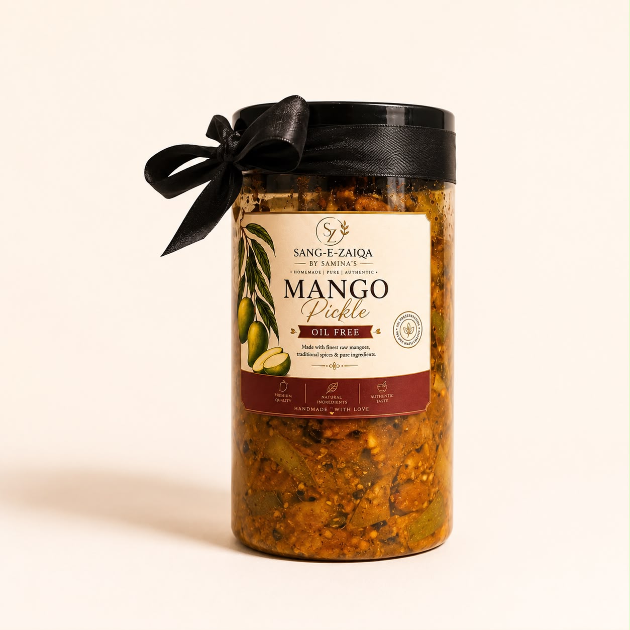 A glass jar of Sang-E-Zaiqa Mango Pickle with a black lid and black ribbon bow, set against a plain off-white background.